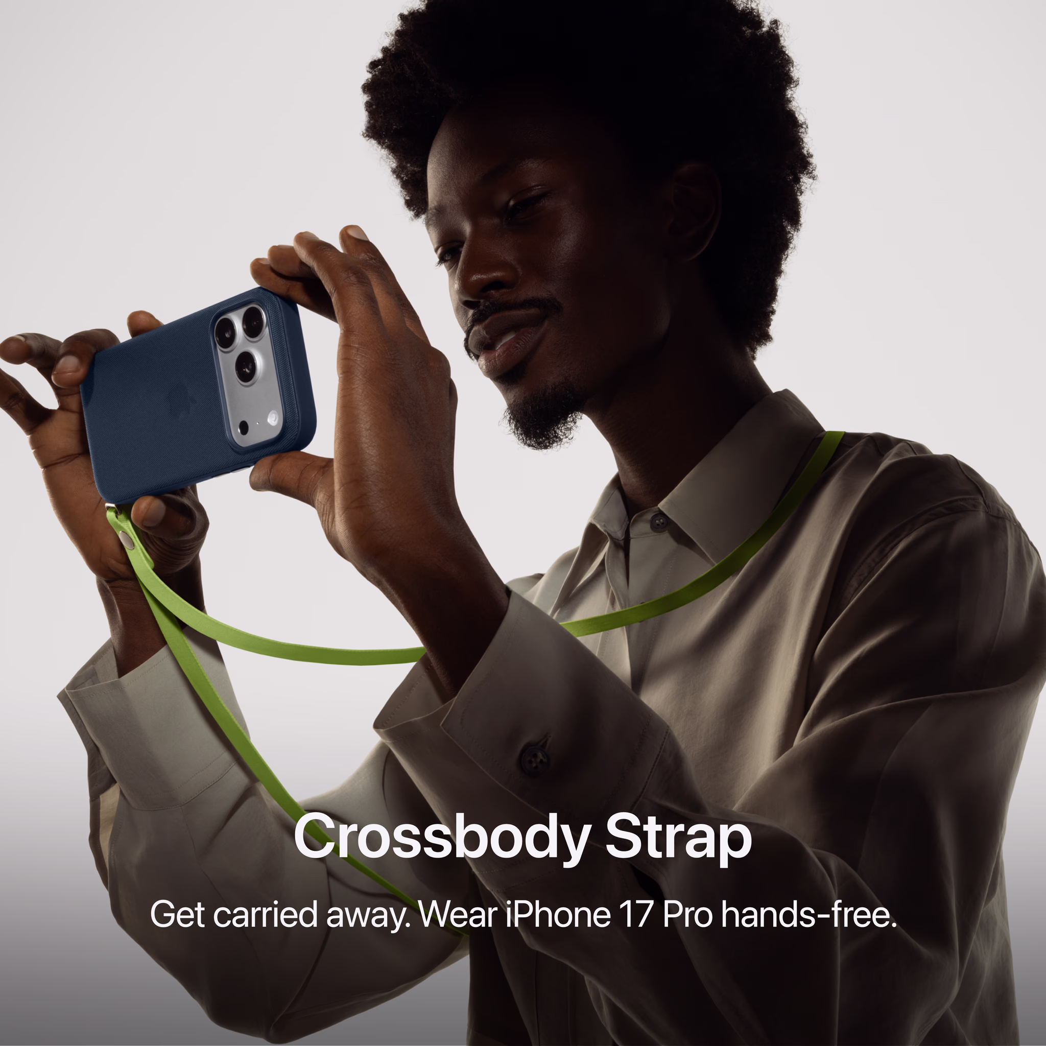 Achterkant van Apple iPhone 17 Pro in donkerblauw hoesje met camera en heldergroene strap